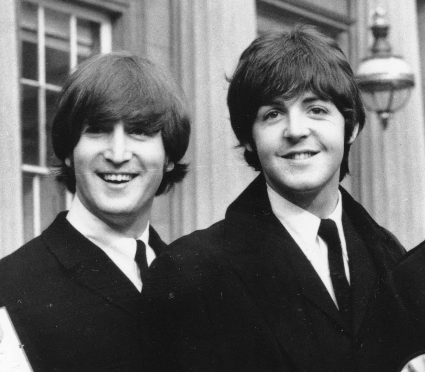 John Lennon (i) y Paul McCartney, componentes de Los Beatles, posan tras asistir a una ceremonia en el Palacio de Buckingham.