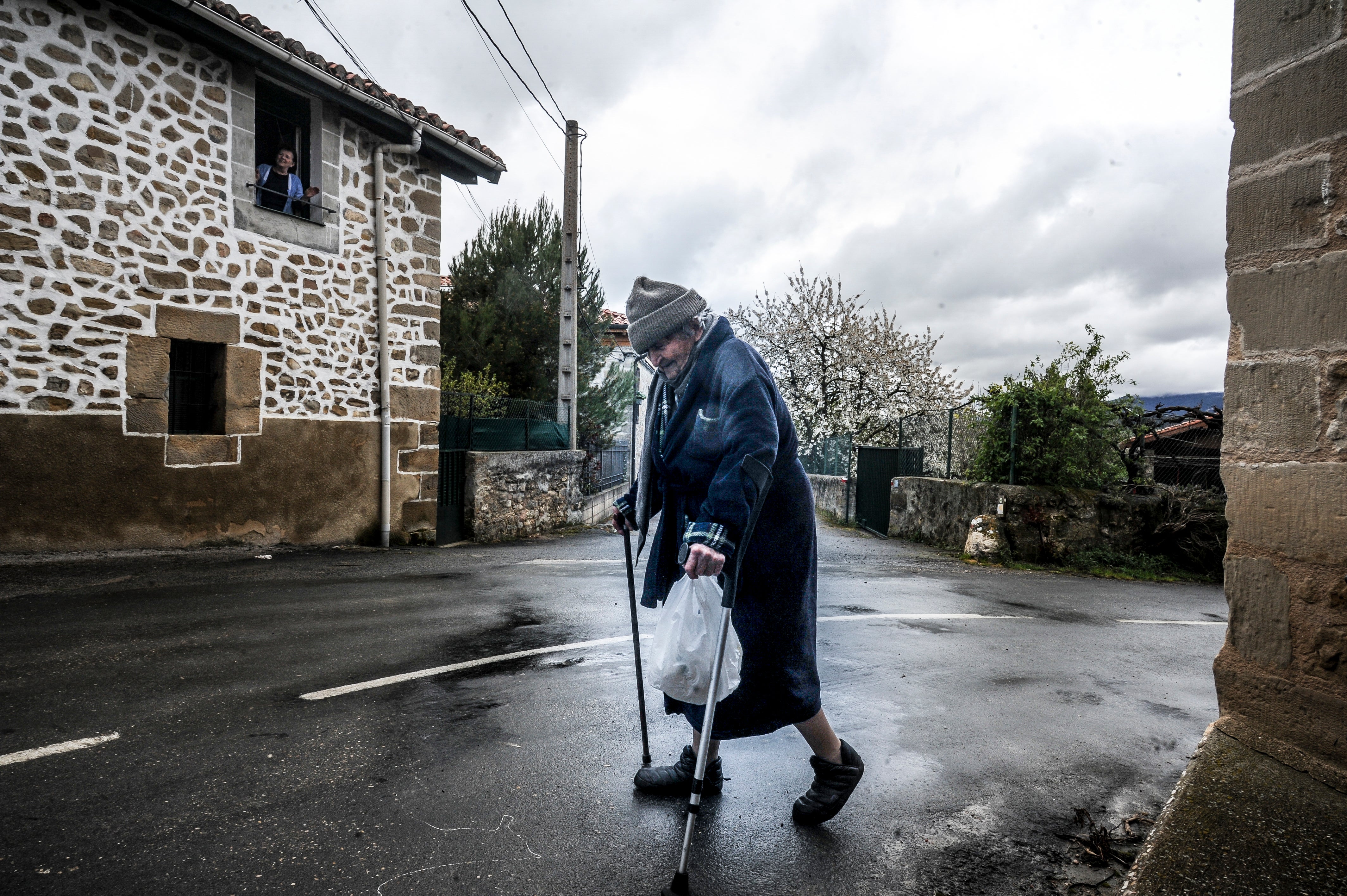 Narcisa, de 86 años, acude a tirar la basura en Villamaderne. Es el único momento en el que sale de su casa.