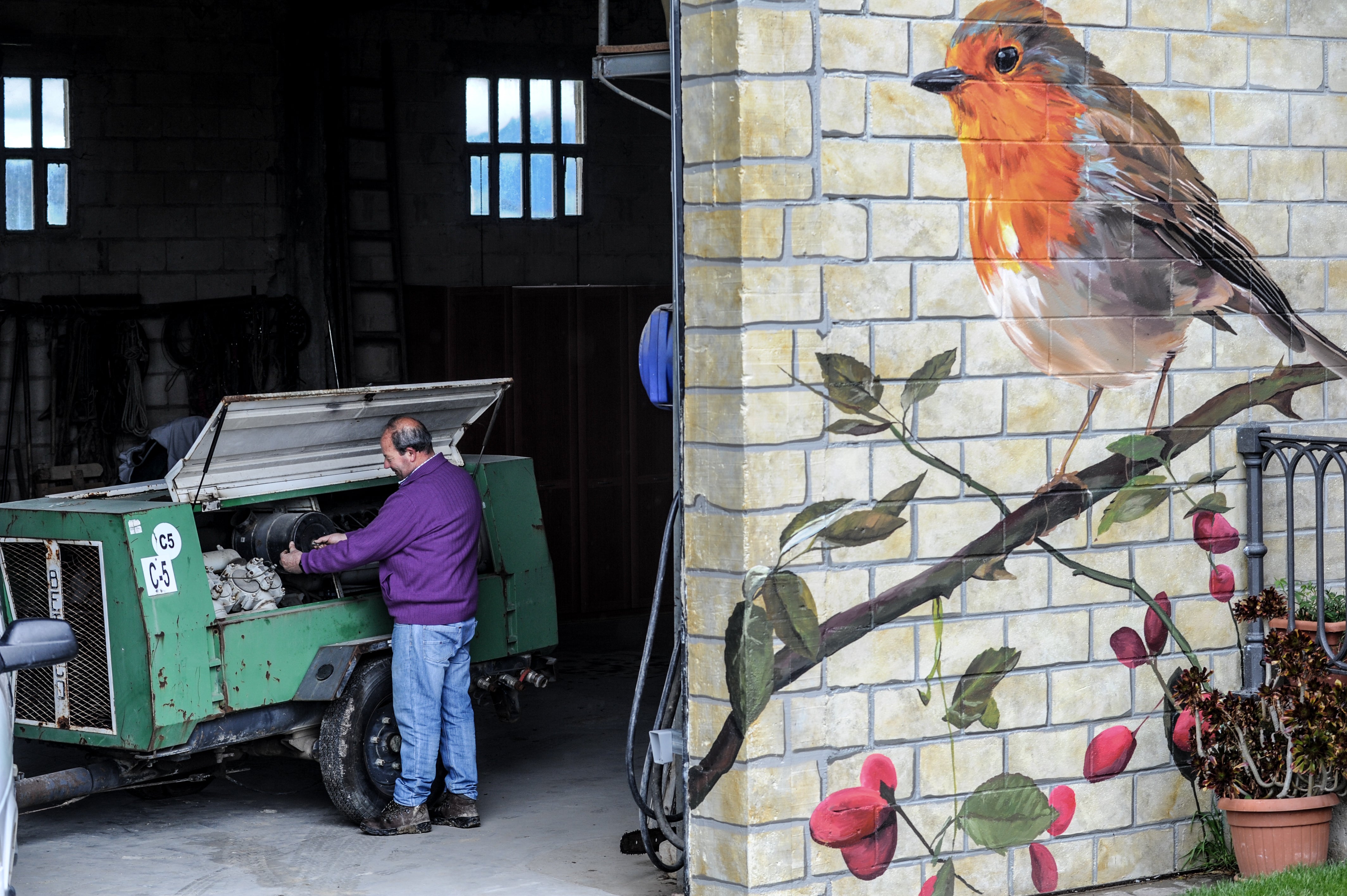 Antonio ajusta la puesta a punto de su máquina compresora de aire después de aplicar herbicida para proteger su cultivo en Villamaderne.