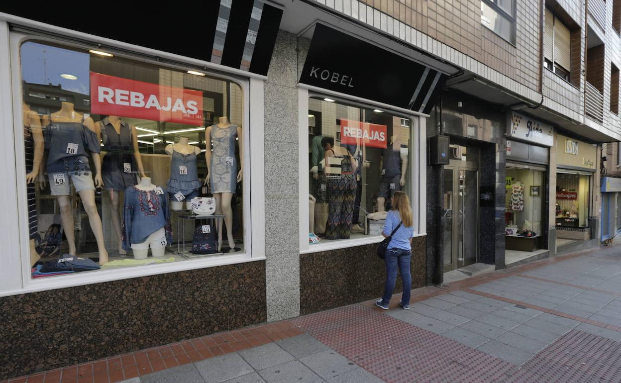 Una mujer observa el escaparate de una tienda de Sesto durante las rebajas. 