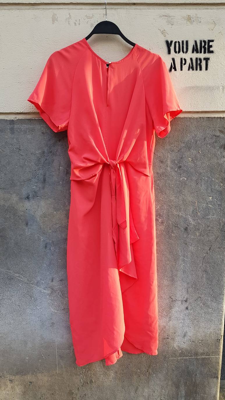 Vestido 'midi' naranja con detalle en la cintura y manga corta. Disponible en la tienda Moiqut, en la calle Ercilla (69 euros). 