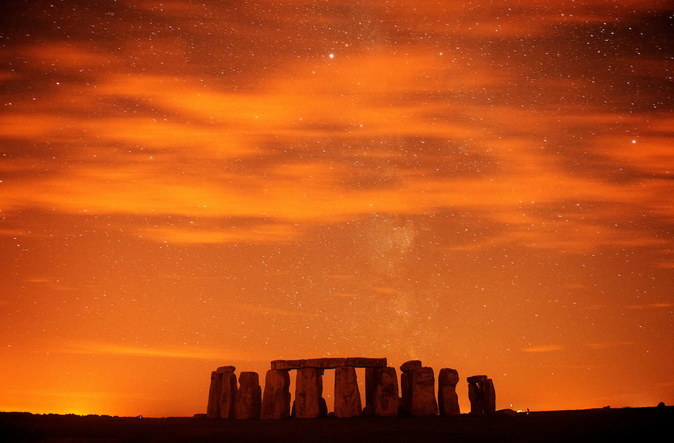 Anochecer en Stonehenge durante la lluvia anual de meteoros. Perseidas en el cielo nocturno en Salisbury Plain, sur de Inglaterra.