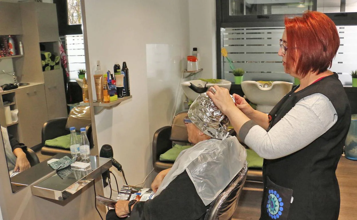 Una trabajadora de una peluquería atiende a una clienta.