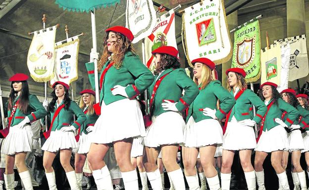 Las majorettes bailan los estandartes de las sociedades gastronómicas que participan en la marcha. 