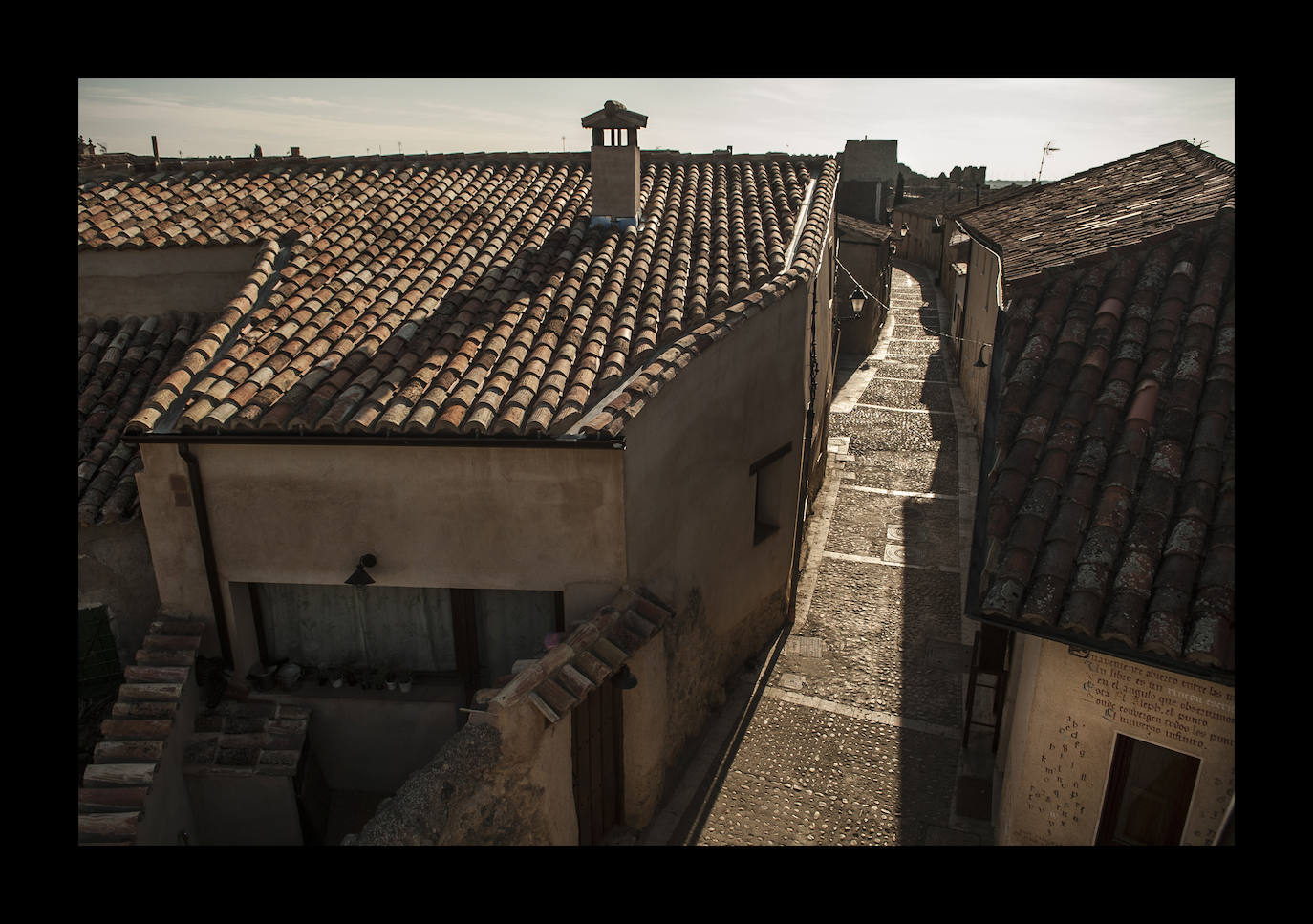 Calle Lagares, pegada a la muralla del siglo XII, y en primer plano la librería 'El Rincón del Ábrego', con un fragmento del Aleph de Borges escrito sobre el dintel de la puerta. El censo de la población ronda las 180 personas, aunque sus vecinos calculan que no habrá más de 40 casas abiertas todo el año y sólo hay cinco menores de edad.
