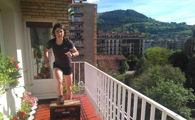 La atleta guipuzcoana Ainhoa Sanz subiendo a las cajas que colocó en su balcón. 