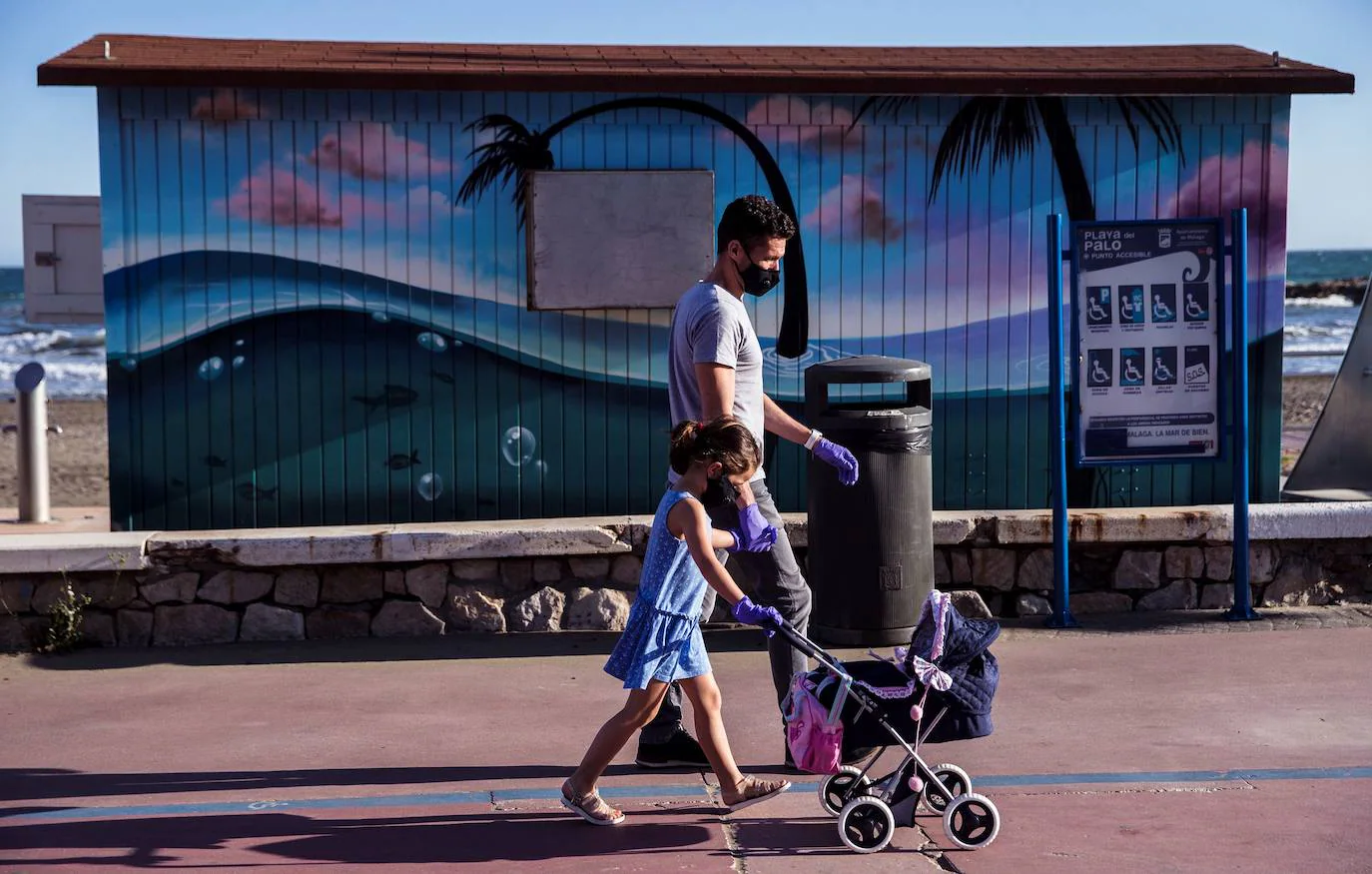 Una niña pasea con su padre en Málaga.