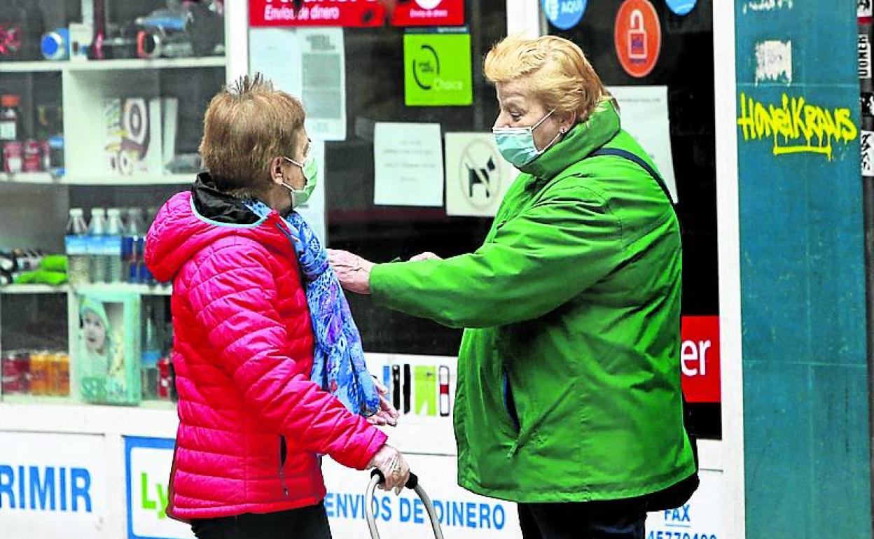 Dos mujeres ajenas al artículo hablan en la calle. 