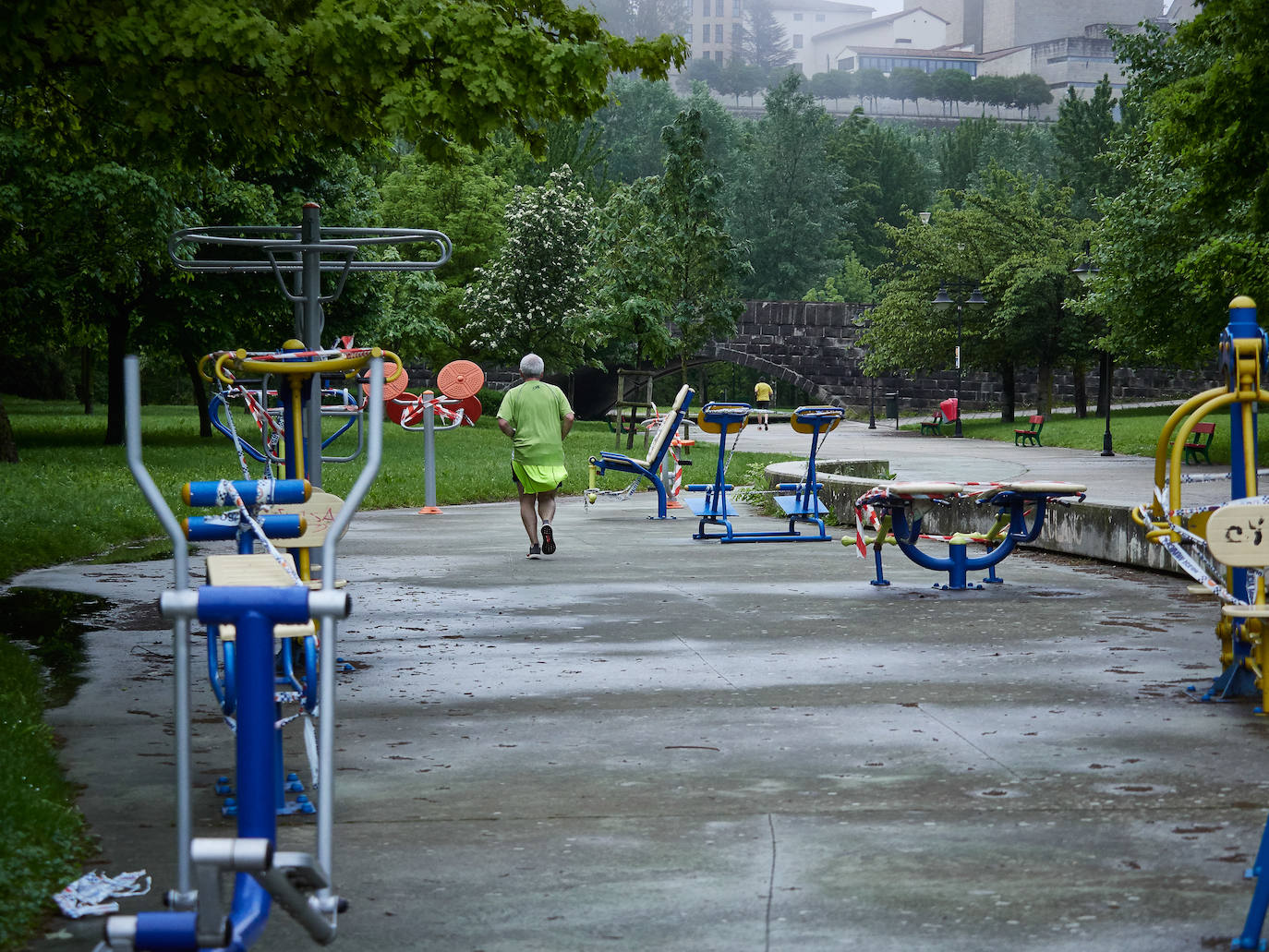 Un corredor atraviesa una zona infantil en Pamplona. 