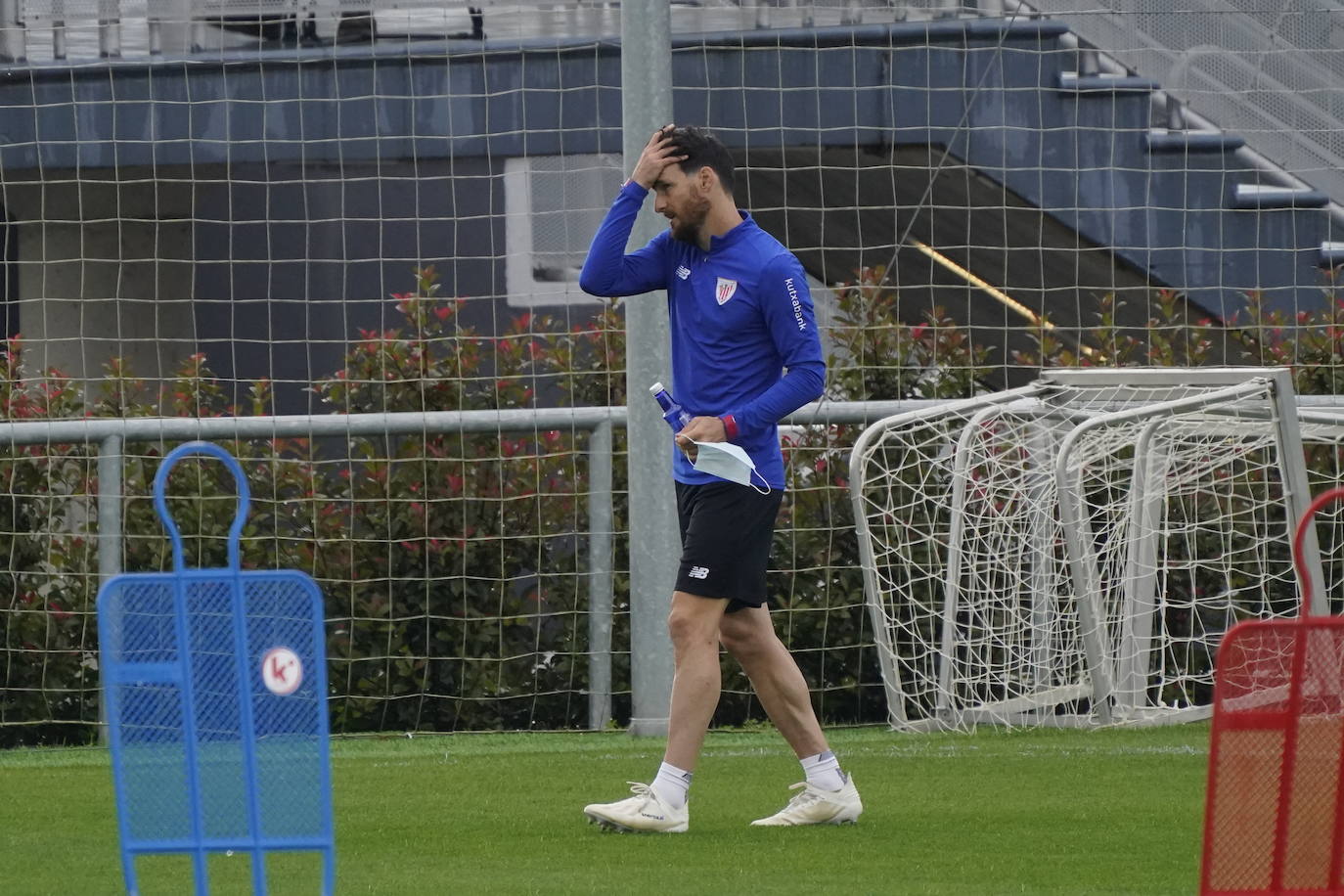 Aduriz se dirige a entrenar con la mascarilla en la mano.