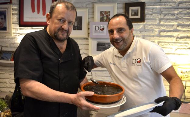 Los responsables de D.O Bilbao con una Cazuela de chipirones en su tinta. 