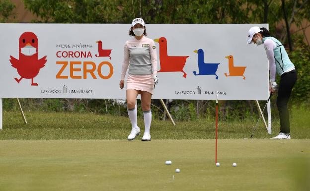 Imagen principal - Arriba, campo de entrenamiento, y sobre estas líneas el comedor con mesas individuales y otra de las golfistas con su mascarilla. 