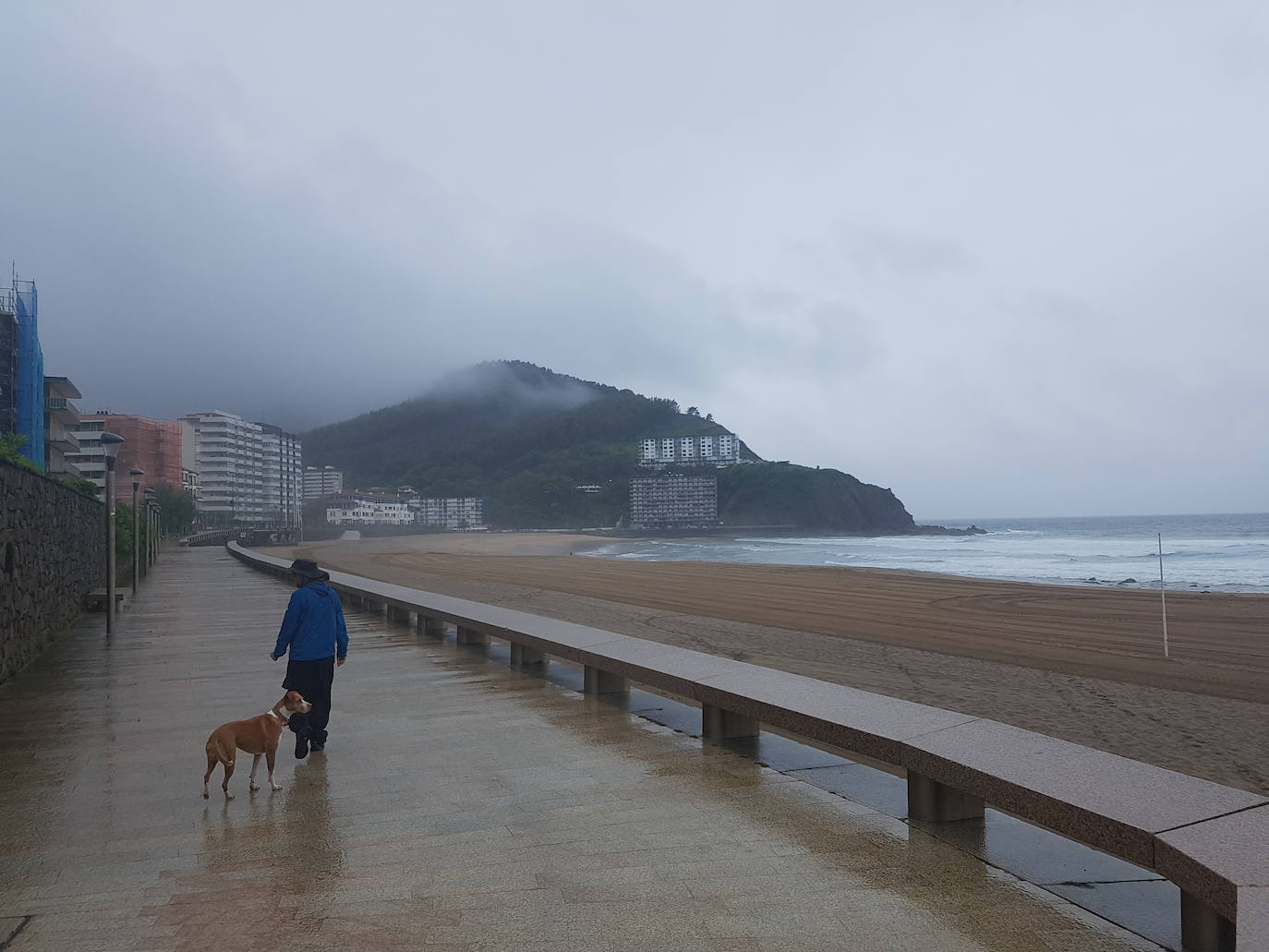 Apenas se dejan ver algunos vecinos esta mañana por las calles de Bakio. A estas horas, la playa se muestra prácticamene vacia en la localidad turística. La lluvia ha frenado sin duda los planes de muchos bilbaínos de acudir este fin de semana a disfrutar de su segunda residencia.