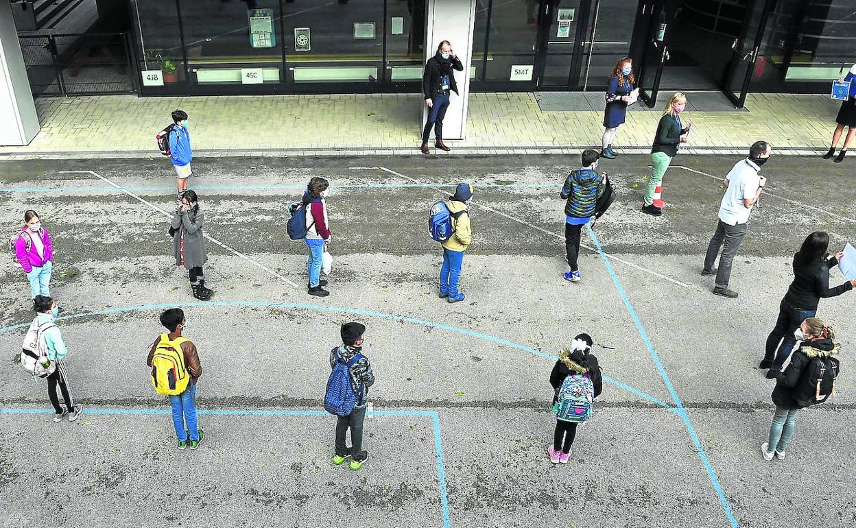 Los alumnos de un centro educativo de Múnich mantienen las distancias provistos de mascarillas en el patio. 