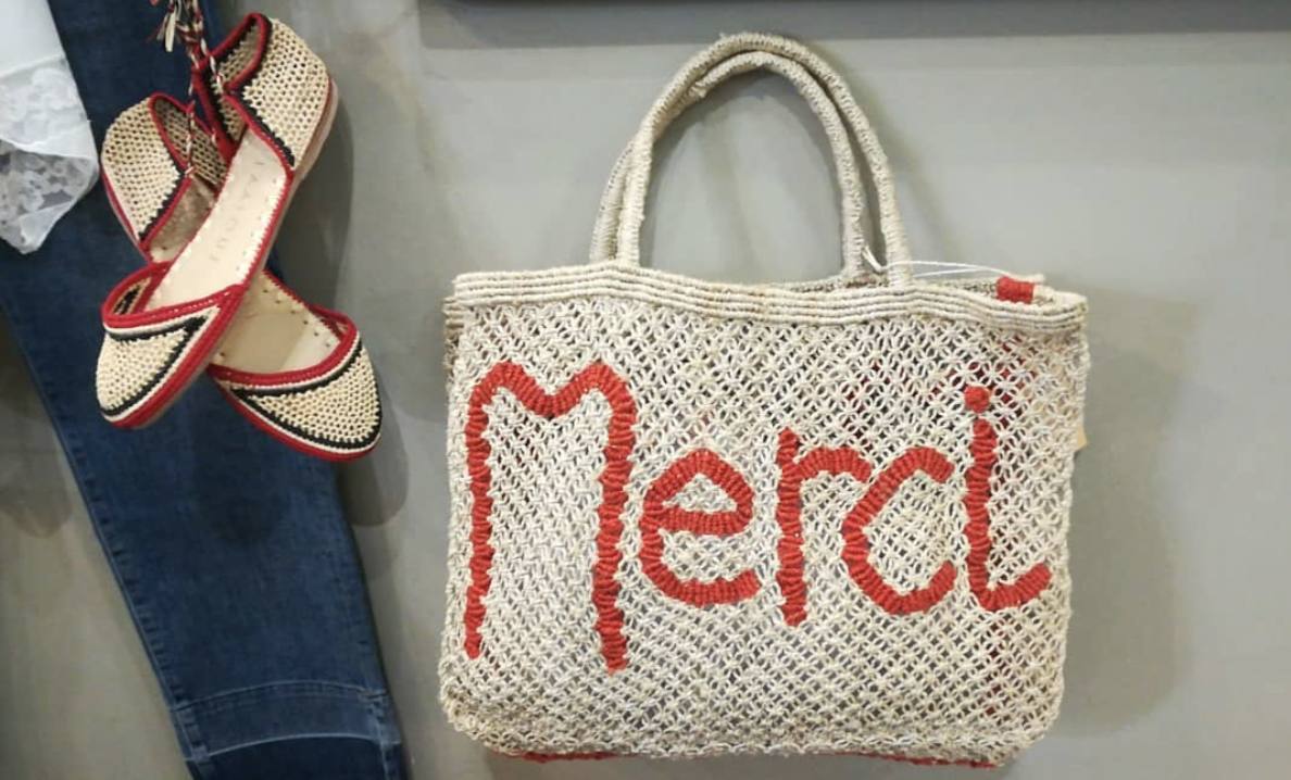 Bolso de yute blanco con el mensaje 'Merci' en rojo. Disponible en la tienda Inarkadia, situada en la plaza Federico Moyua.