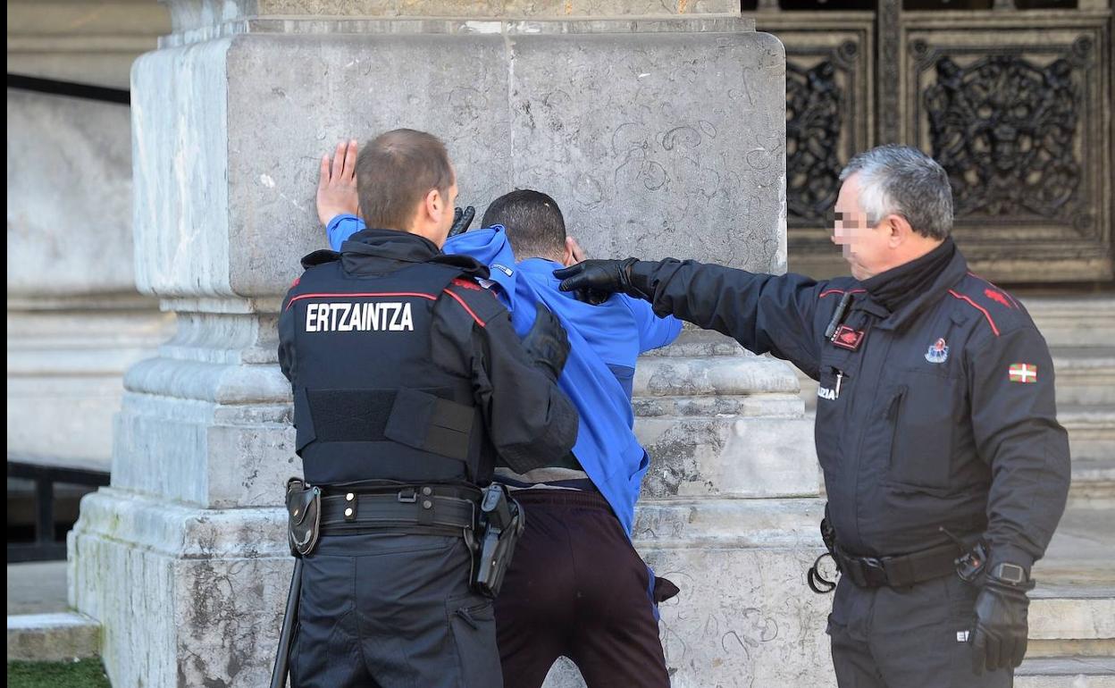 Dos ertzainas detienen a un joven en plena Gran Vía de Bilbao.