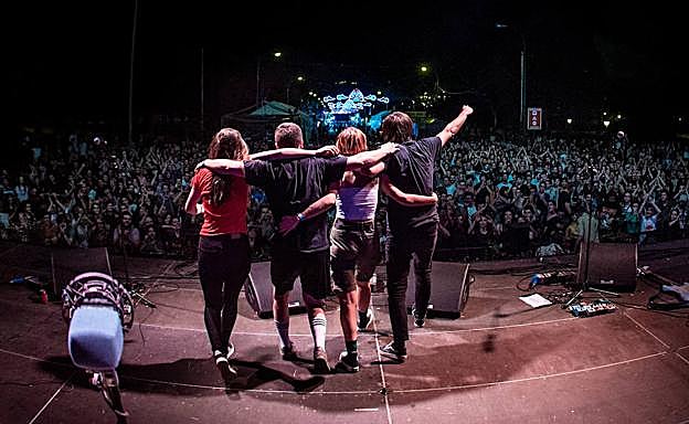 Imagen principal - Arriba, la banda despidiéndose de su público. Debajo, Cris y Josu.