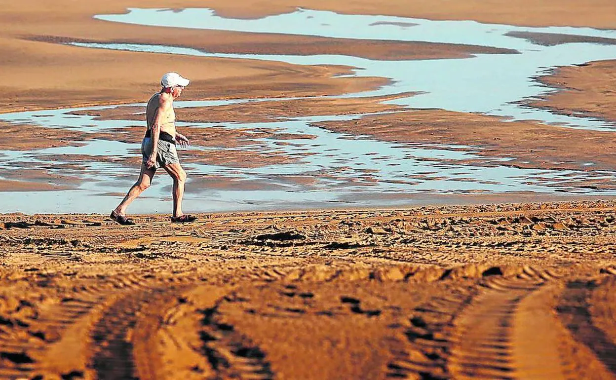 Un hombre pasea por la marisma que forma el Barbadún en su encuentro con el mar a la altura de Zierbena. 