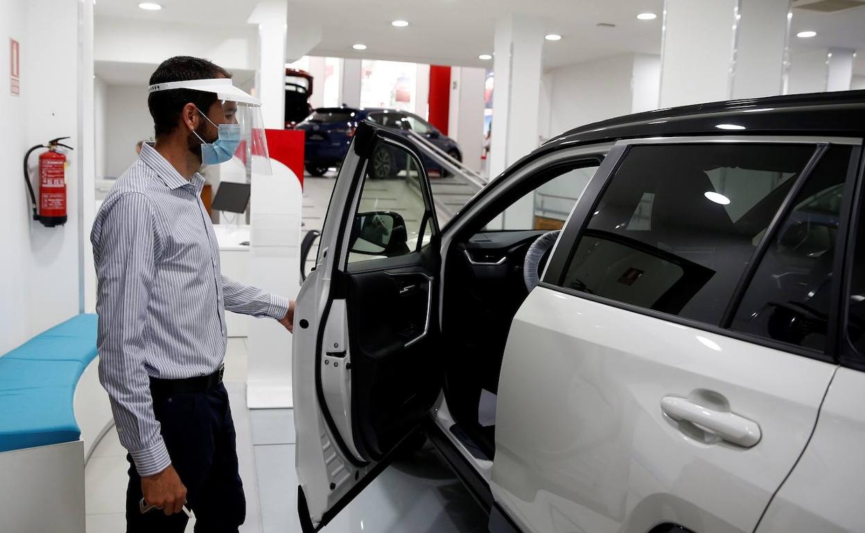 Un vendedor muestra un coche en un concesionario