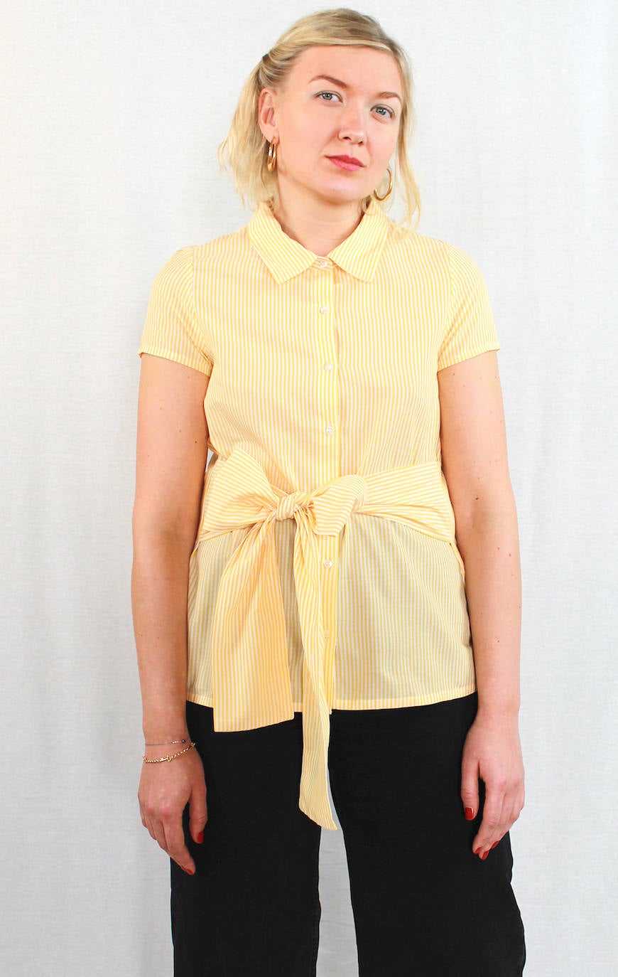 Camisa de rayas amarillas con lazada en la cintura de la firma española Compañía Fantástica. Costaba 29,95 euros y ahora la puedes adquirir por 23,95 euros en la tienda bilbaína Uoma, situada en Rodriguez Arias. 