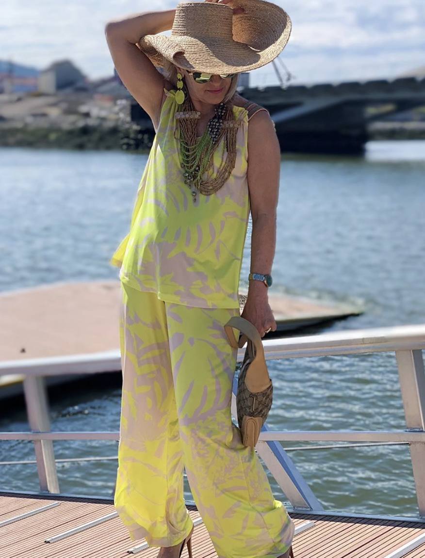 Se atreve a lucir como nadie unos conjuntos muy llamativos. Como el que muestra en la imagen, compuesto por un top y pantalón largo con un estampado tropical en tonalidades amarillas y crudas. El complemento estrella del look es una pamela XL de rafia al más puro estilo Jacquemus.