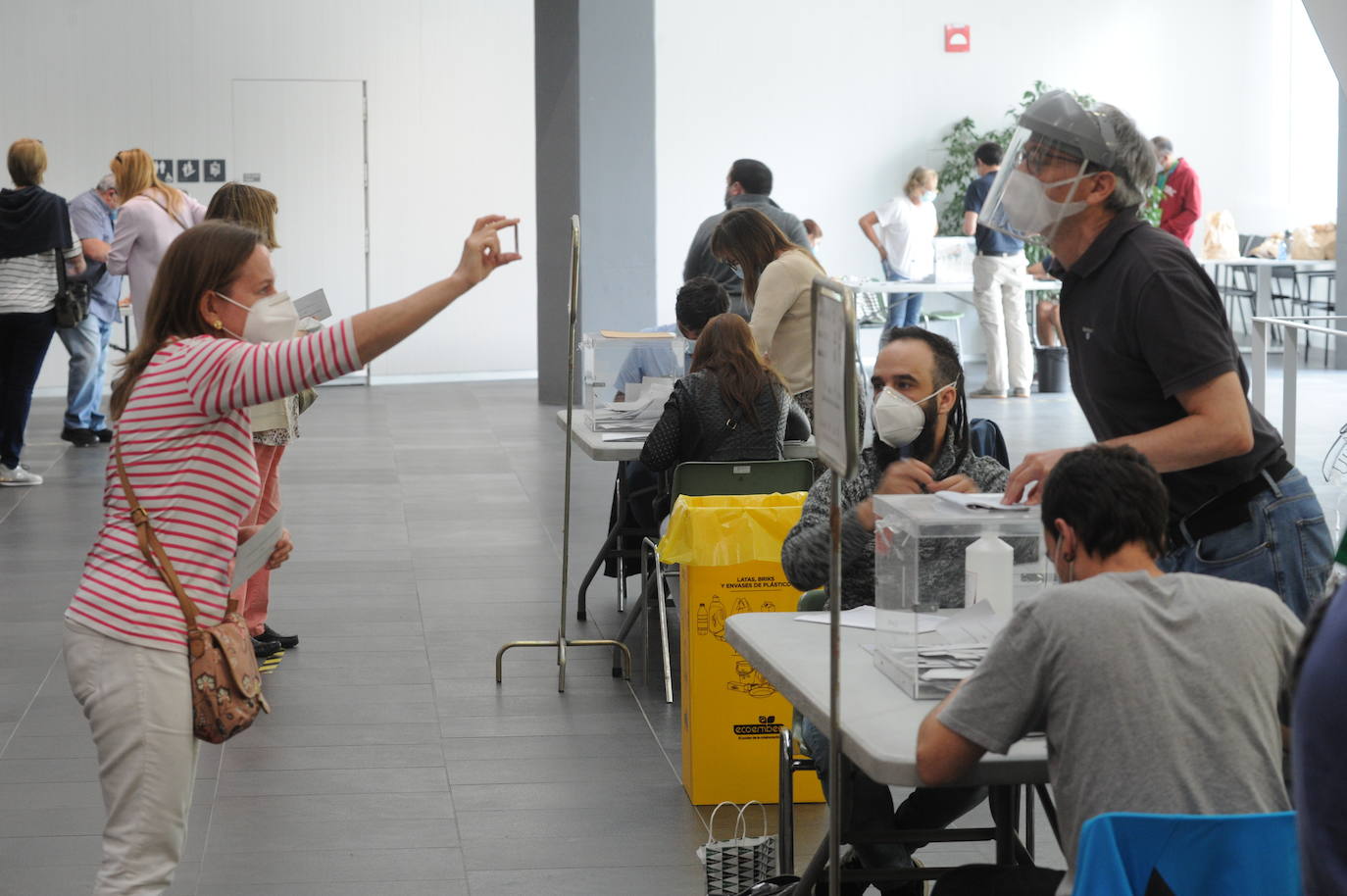 Una votante muestra su documentación a distancia en el colegio electoral de las oficinas de San Martín. 