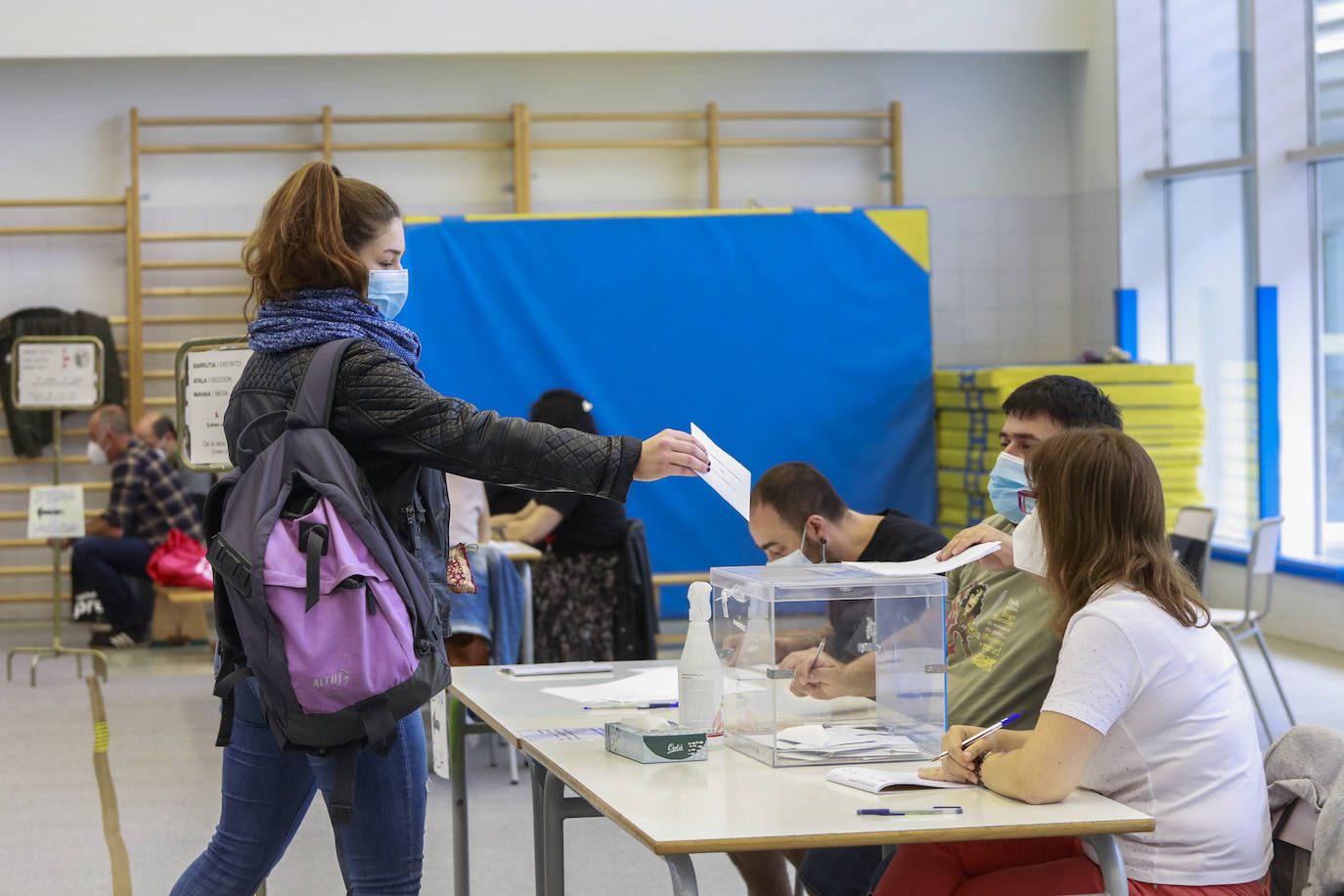 Una joven deposita su voto en la urna ubicada en una de las mesas electorales que se han instalado en el colegio de Primaria de Ibaiondo.