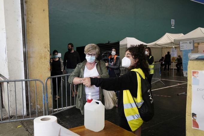 Una mujer se lava las manos antes de acudir a votar.