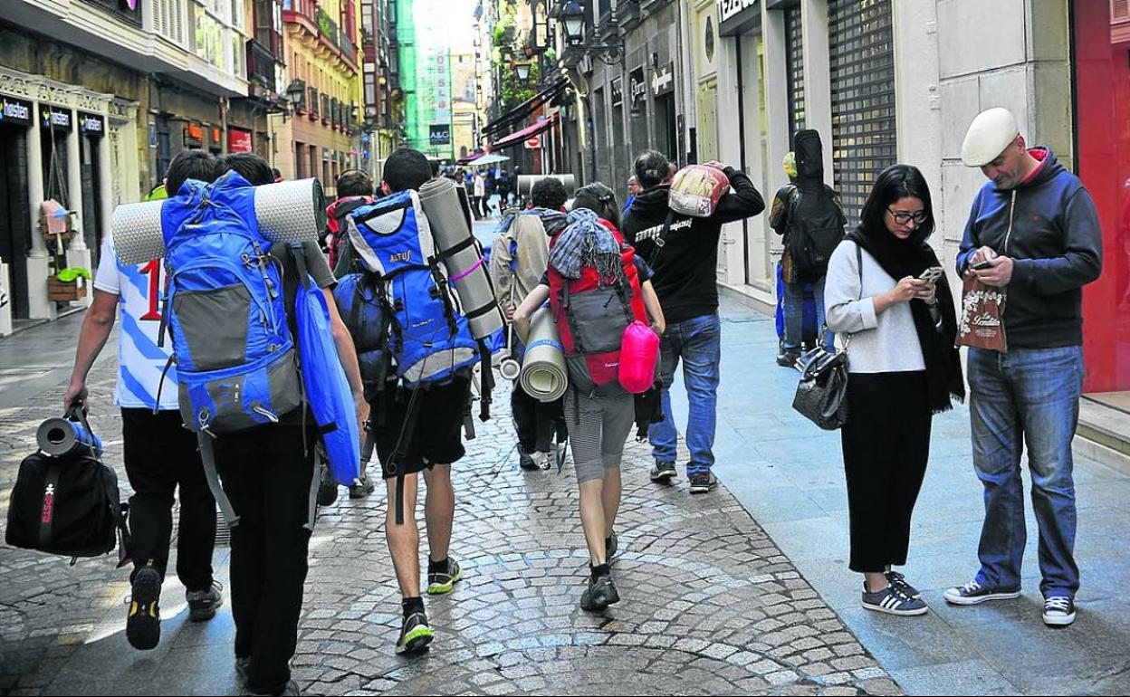 Jóvenes cargan sus mochilas para acampar en un festival antes de que el virus lo cambiase todo.