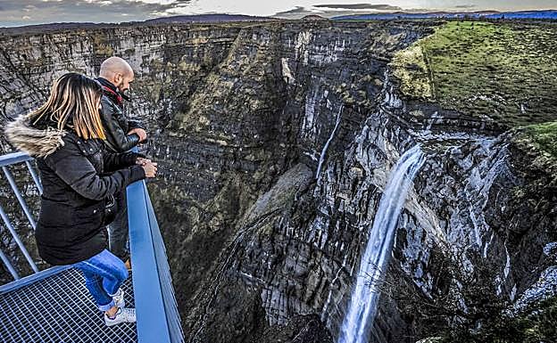 Una pareja observa el salto desde un mirador.