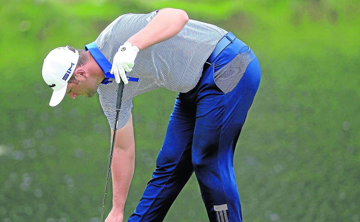 Jon Rahm se ajusta las zapatillas durante la vuelta de ayer en The Memorial. 