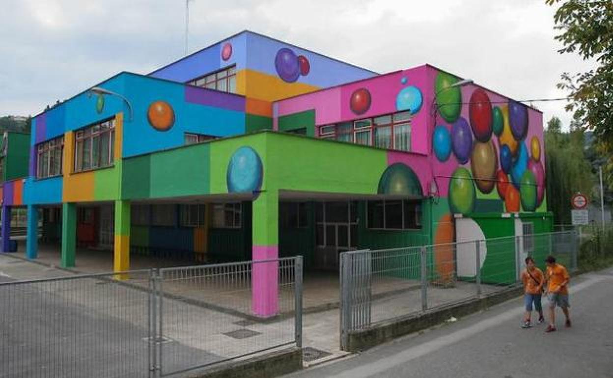 Dos jóvenes pasan por delante de la escuela de colorines de Lekeitio. MAIKA SALGUERO. 