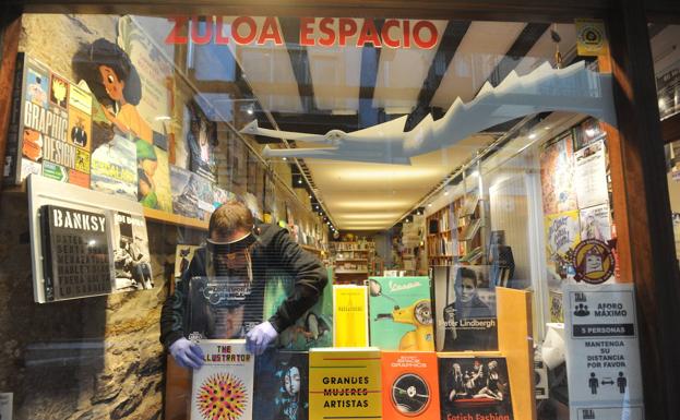 Txintxu San Martín prepara el escaparate de la librería Zuloa. 