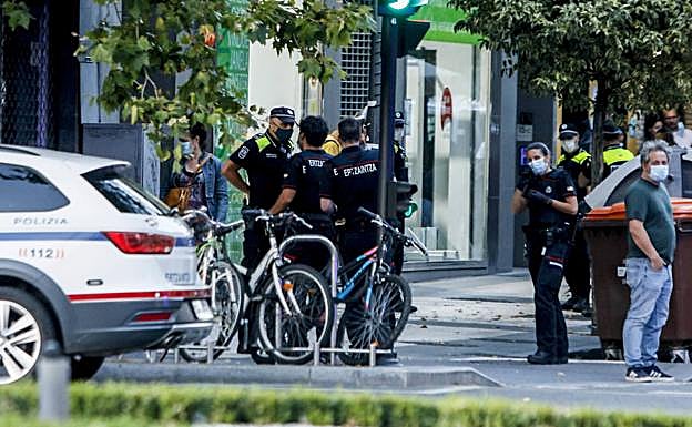Imagen principal - Arriba, agentes locales y ertzainas en la calle Reyes Católicos, donde se produjo el arresto. Abajo, policías con amigos de los implicados en la calle La Peña.