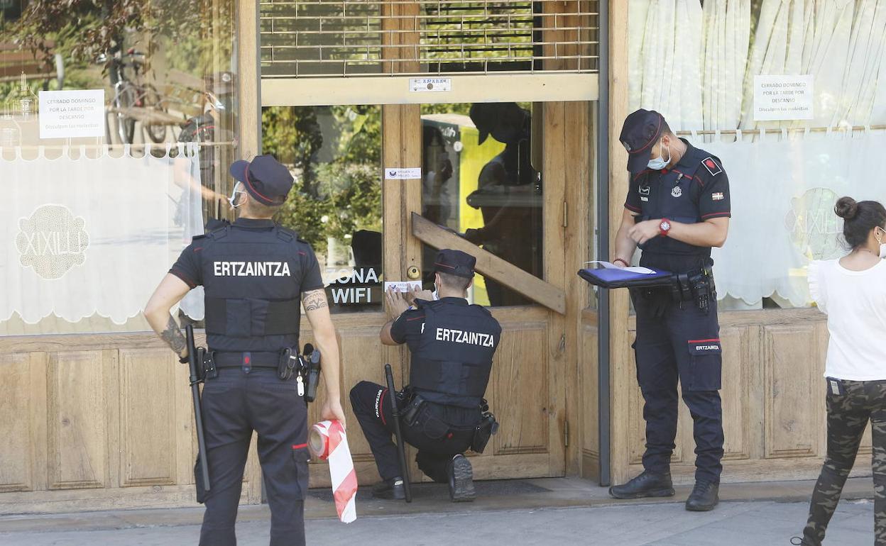 Agentes de la Ertzaintza precintan el restaurante Xixilu. 