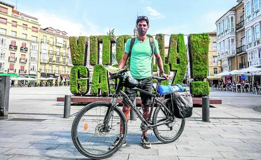 El joven galo posa con su bici ante el seto 'green' de la Virgen Blanca.