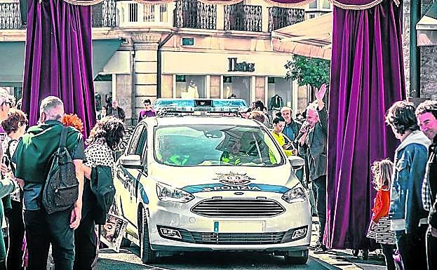 Teatro vivo en la calle. Un coche policial atraviesa el telón del montaje Al otro lado', de Zanguango.