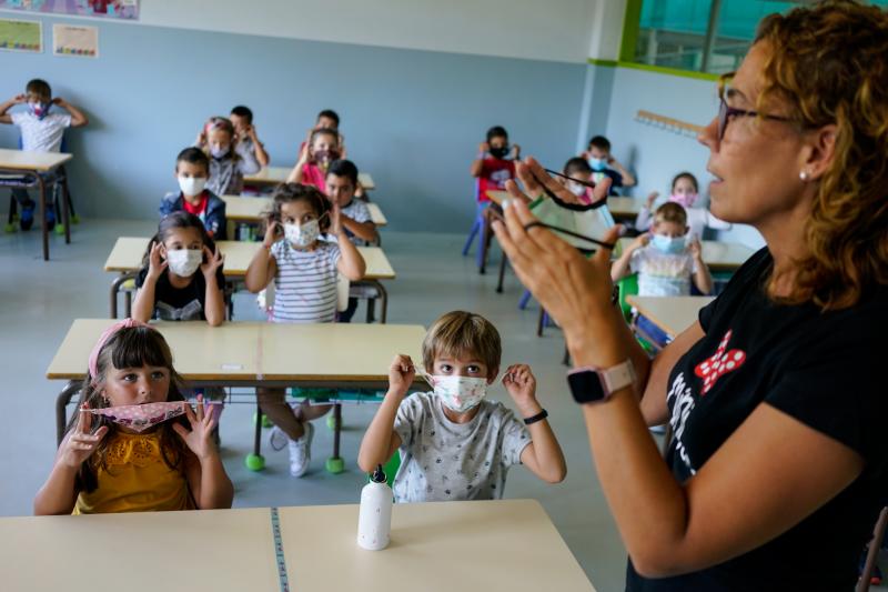 Una profesora enseña a los niños cómo ponerse la mascarilla en un colegio de Ermua. 