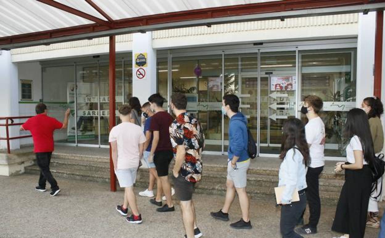 Un profesor dirige a los alumnos a su aula en el primer día de clase en Mendizabala. 