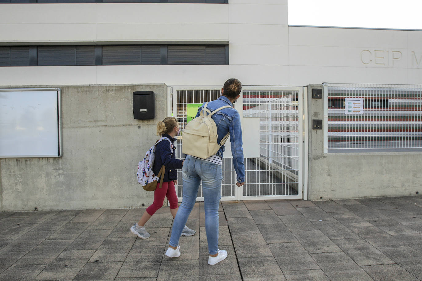 Una niña se acerca a la puerta del colegio público Mariturri, en Zabalgana.