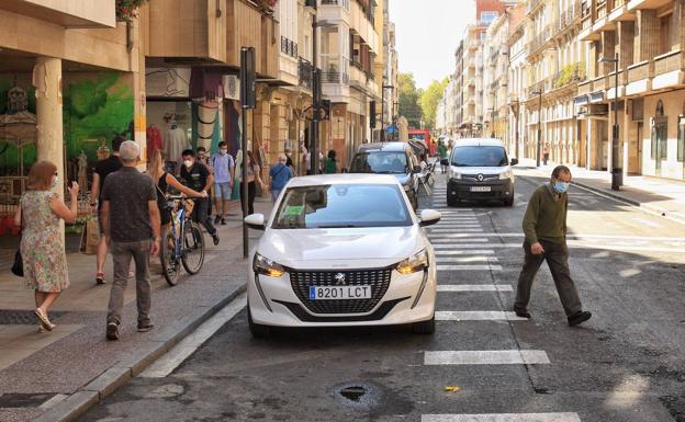 Imagen principal - La acera de los números pares soporta el mayor número de transeúntes. Algunos, en bicicleta. 