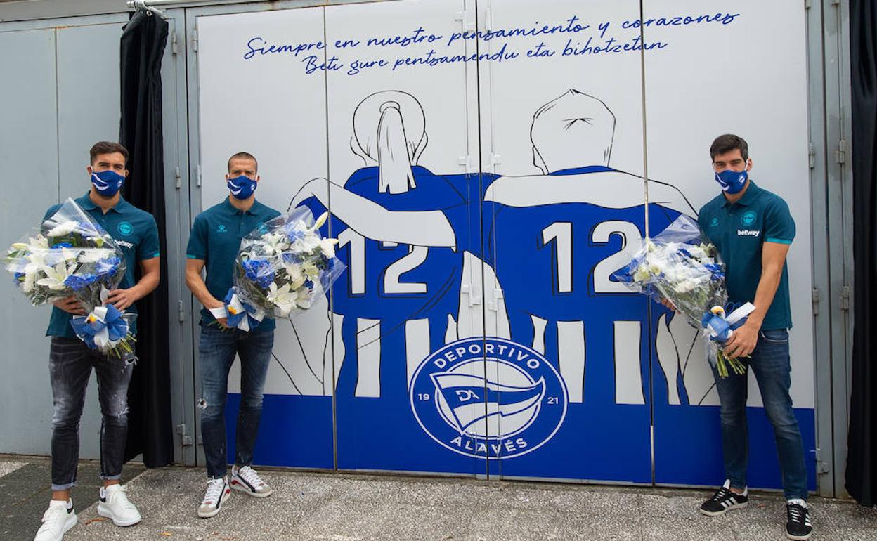 Manu García, Fernando Pacheco y Víctor Laguardia han depositado a los pies del mural unas flores a modo homenaje. 