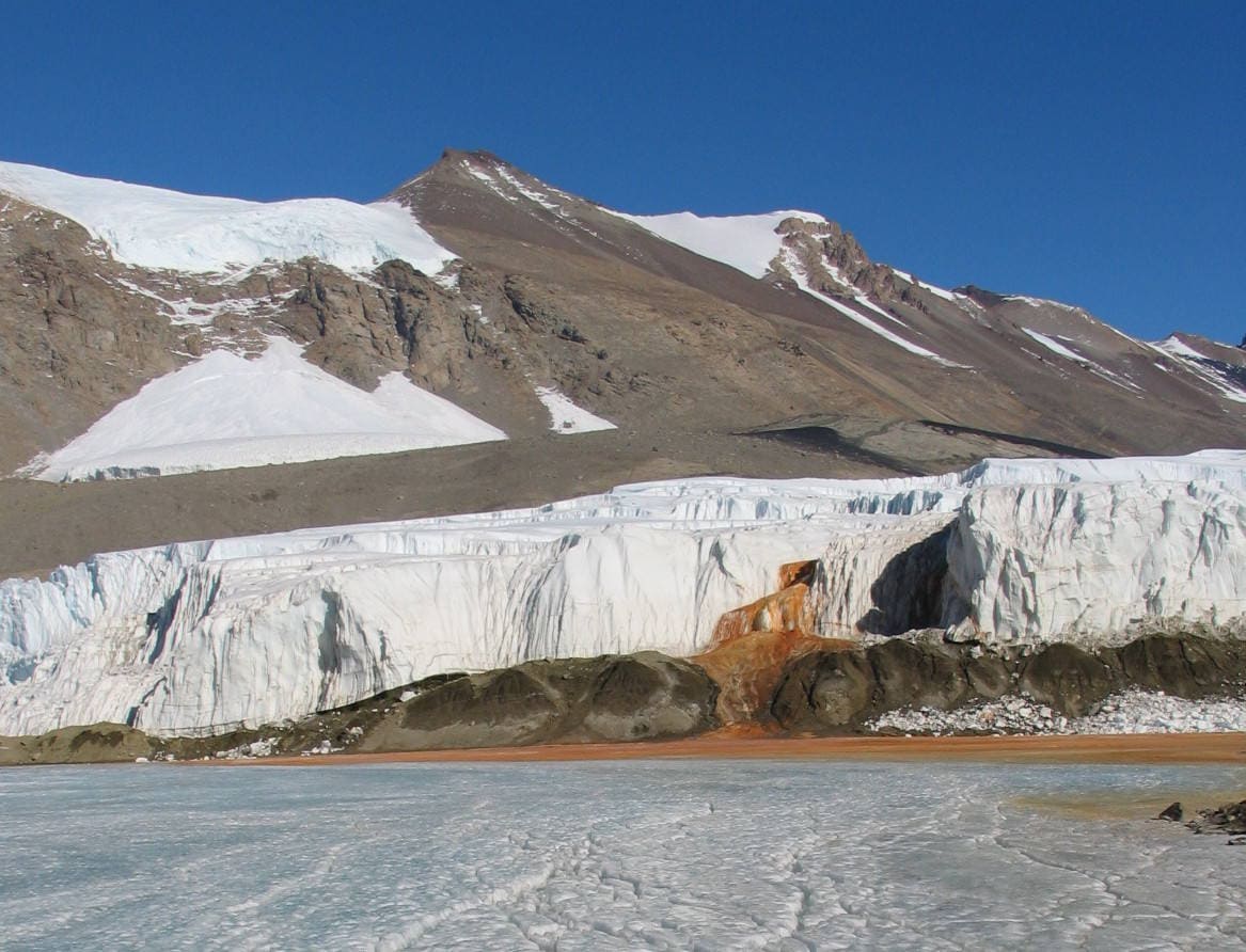 'Cataratas de sangre' de la Antártida | Una mancha roja emerge del glaciar Taylor, como una fuente de sangre en medio del impoluto blanco del hielo. Su origen se debe a que bajo el glaciar se encuentra una corriente de agua muy salina, con un elevado nivel de óxido de hierro que deja ese particular color en la superficie del lugar.