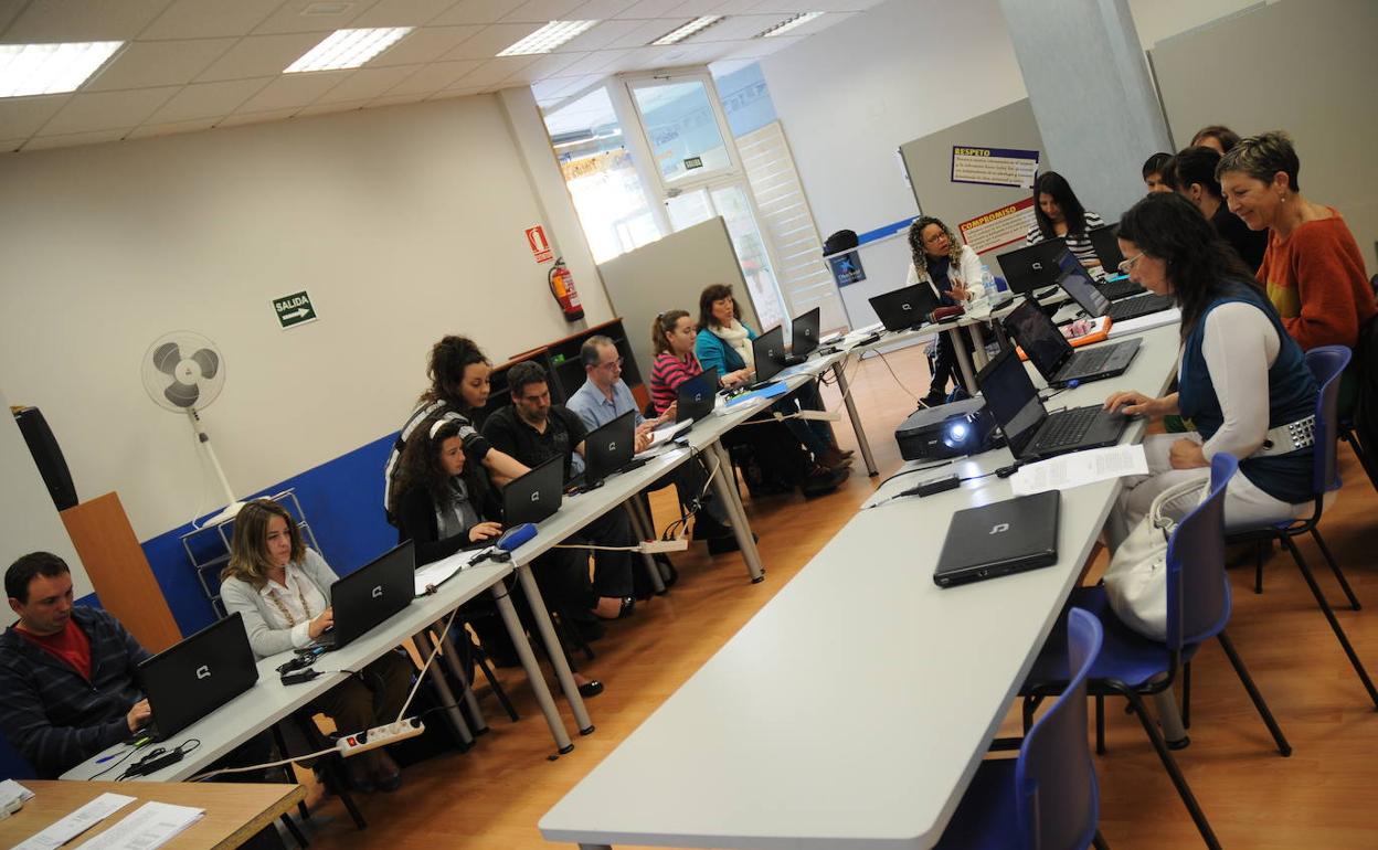 Los alumnos de un curso de formación promovido por Ymca atienden las explicaciones de su monitora en la sede de la fundación. 