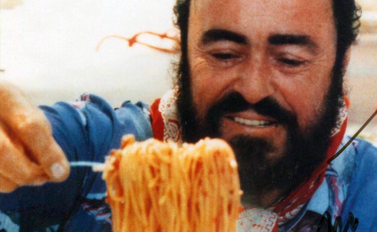 Luciano Pavarotti sirviendo pasta. 