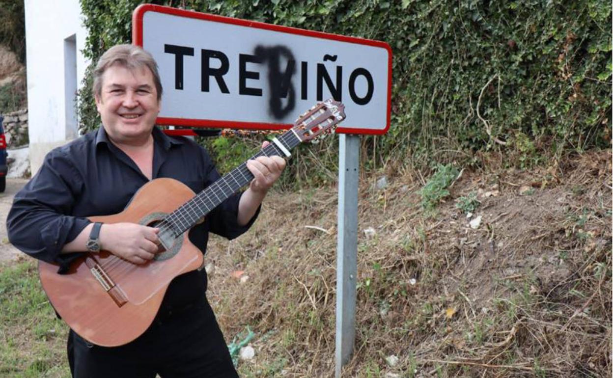 El cantante y compositor Iñaki Basabe, guitarra en mano, ante el cartel de Treviño