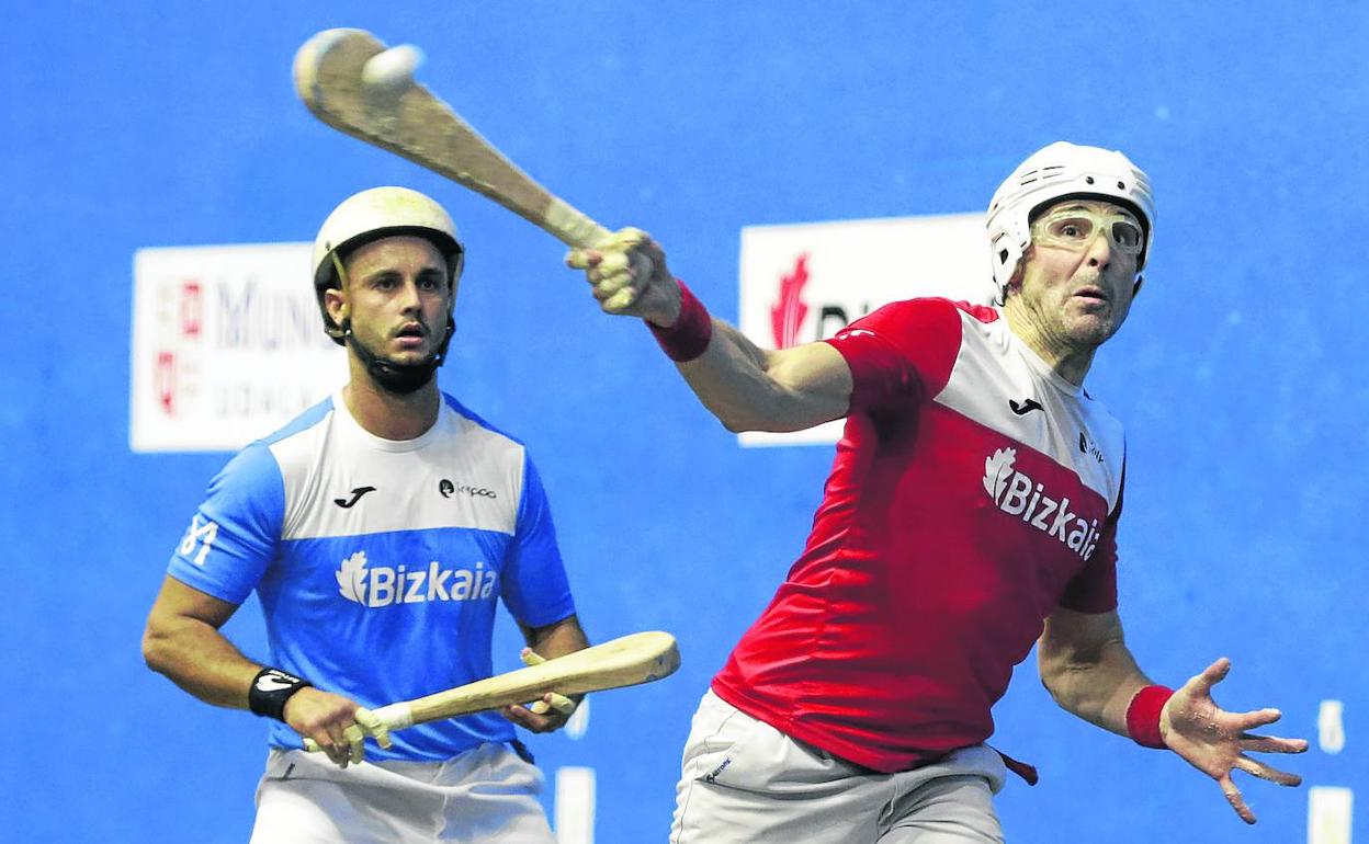 Gaubeka empala una pelota con la derecha ante la mirada de Garate en el frontón de Mungia. 