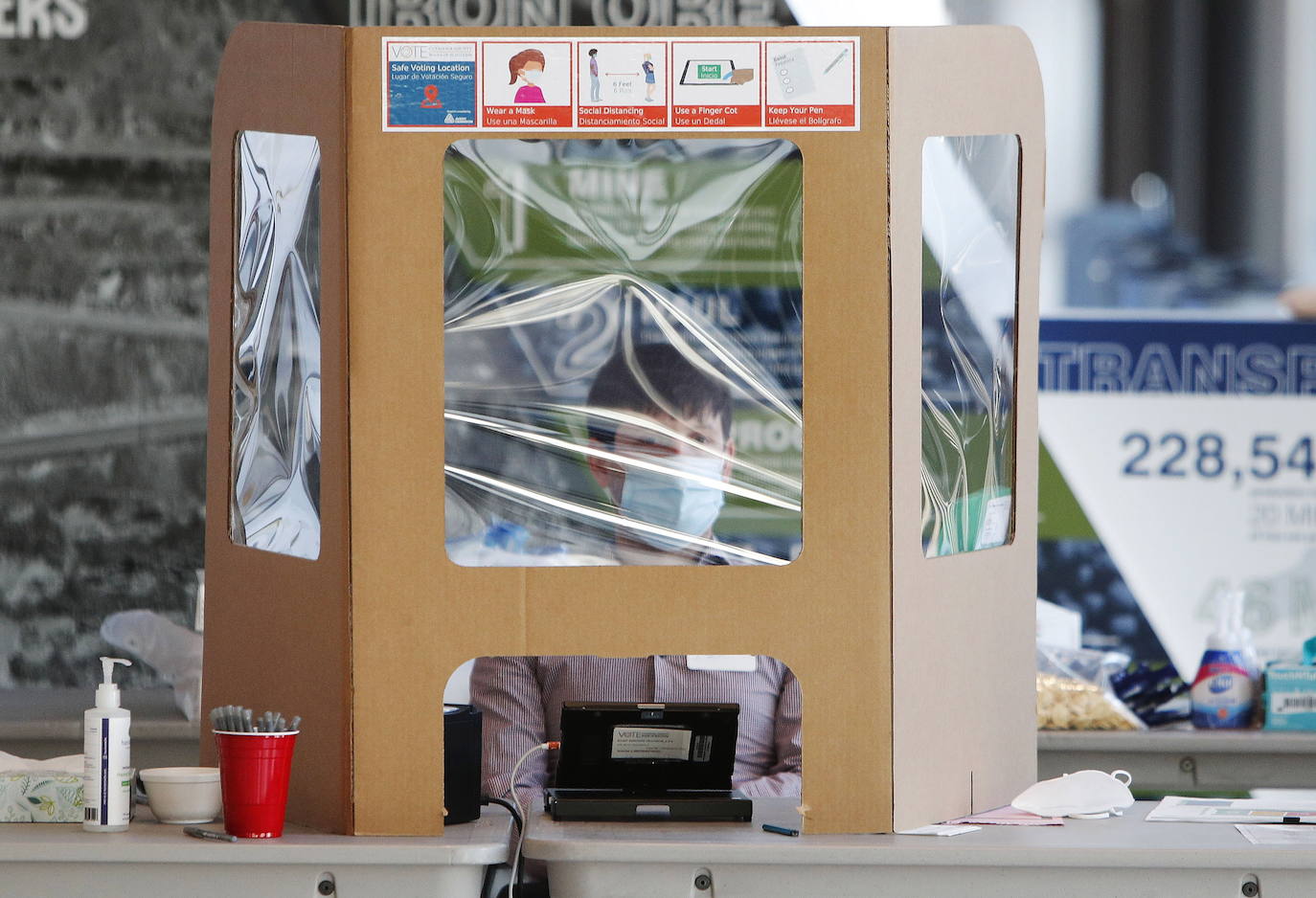 Un trabajador electoral toma precauciones contra la transmisión de Covid-19 en un centro de votación en Rocket Mortgage Field House en Cleveland Ohio.