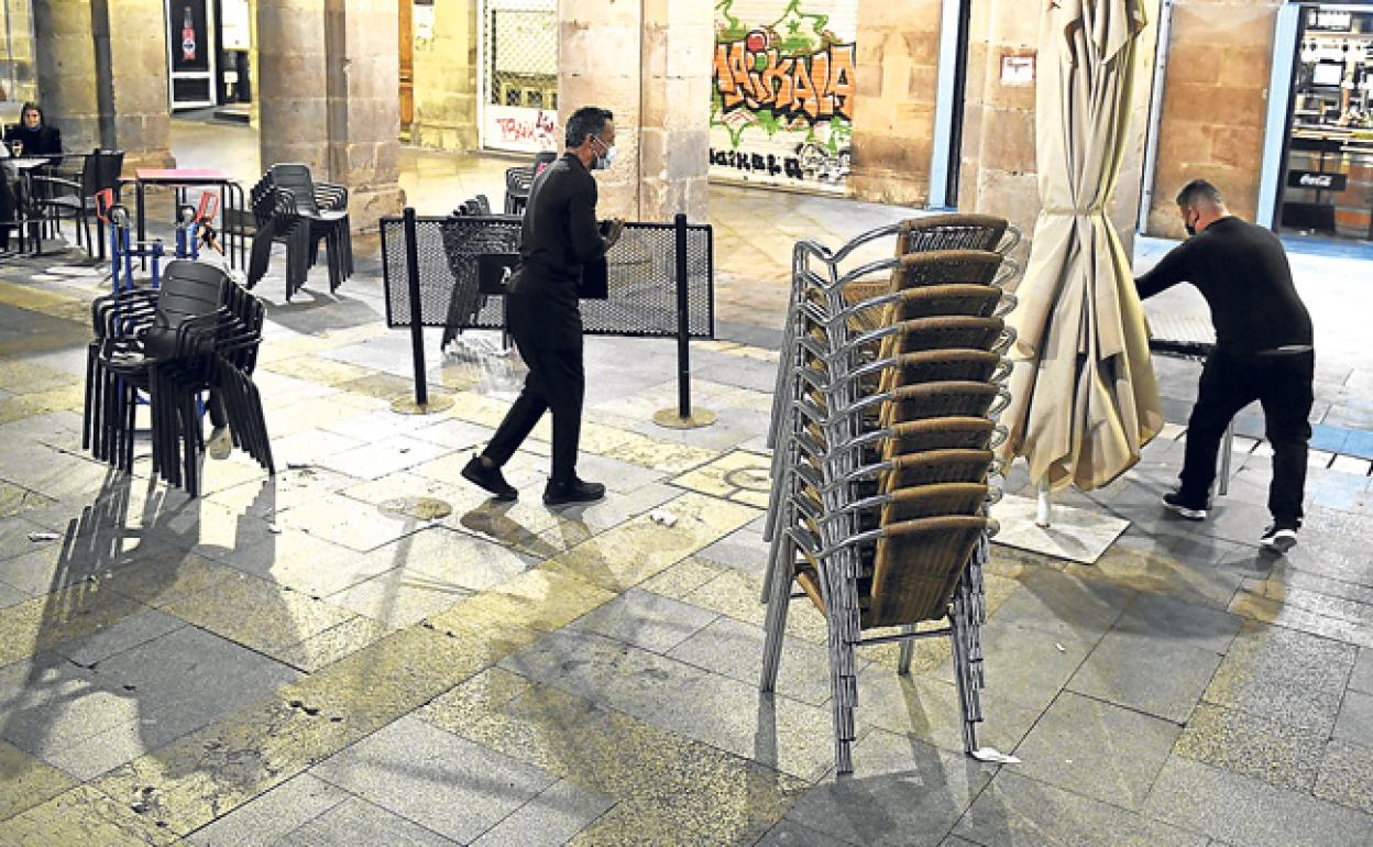 Retirada de las terrazas anoche en la plaza Nueva de Bilbao, una de los estandartes de la hostelería en el Casco Viejo.