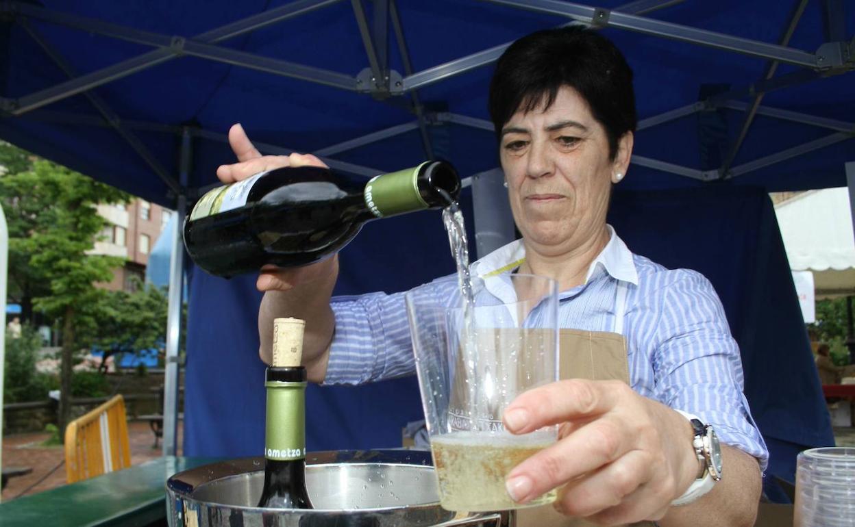 María Ángeles villate sirviendo txakoli en una fiesta en Amurrio. 